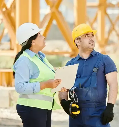 Profissionais de segurança do trabalho com capacete e prancheta em vistoria